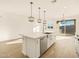 Kitchen island featuring stainless sink, dishwasher, with pendant lighting and wood-look ceramic tile floors at 22490 W Tonopah Dr, Surprise, AZ 85387