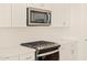 Close-up of modern gas range with stainless microwave and white subway tile backsplash at 22490 W Tonopah Dr, Surprise, AZ 85387