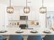 Modern kitchen features white cabinets, a quartz countertop, and stylish pendant lighting at 22490 W Tonopah Dr, Surprise, AZ 85387
