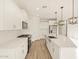 Modern kitchen features white cabinets, stainless appliances, and a center island with quartz countertops at 22490 W Tonopah Dr, Surprise, AZ 85387