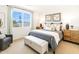 Well-lit main bedroom with a large window, neutral decor, and comfortable furnishings at 22490 W Tonopah Dr, Surprise, AZ 85387