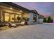 Expansive backyard patio with sleek tiling, a cozy seating area, and manicured greenery at 22609 E Roundup Way, Queen Creek, AZ 85142