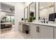 Modern bathroom featuring dual sinks, sleek black fixtures, and elegant white cabinets, with views to the bedroom at 22609 E Roundup Way, Queen Creek, AZ 85142