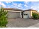Beautiful gray stucco home boasts a paved driveway and a gated front entrance with mature desert landscaping at 22609 E Roundup Way, Queen Creek, AZ 85142