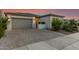 Beautiful gray stucco home boasts a paved driveway and a gated front entrance with desert landscaping at 22609 E Roundup Way, Queen Creek, AZ 85142