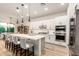 Open kitchen features a large island with seating, white cabinets, stainless steel appliances, and modern pendant lighting at 22609 E Roundup Way, Queen Creek, AZ 85142