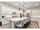 Open kitchen features a large island with seating, white cabinets, stainless steel appliances, and modern pendant lighting at 22609 E Roundup Way, Queen Creek, AZ 85142