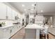 Open kitchen features a large island with seating, white cabinets, stainless steel appliances, and modern pendant lighting at 22609 E Roundup Way, Queen Creek, AZ 85142