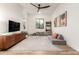 Minimalist living room with a modern entertainment center, a gray couch, and neutral decor at 22609 E Roundup Way, Queen Creek, AZ 85142