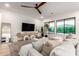Bright living room with large windows, a modern ceiling fan, and a comfortable sectional couch at 22609 E Roundup Way, Queen Creek, AZ 85142