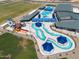Aerial view showcases the water park with colorful slides, pools, and interactive water play areas at 22609 E Roundup Way, Queen Creek, AZ 85142