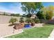 Backyard featuring an artificial grass lawn and custom water feature with stone accents at 2310 W Sienna Bouquet Pl, Phoenix, AZ 85085