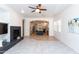 Open-concept living room with fireplace, ceiling fan, and view of kitchen with large island at 2310 W Sienna Bouquet Pl, Phoenix, AZ 85085