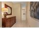 Hallway with tile flooring, wooden dresser, decorative lamp, and zebra artwork, creating an inviting interior space at 24158 N 78Th Pl, Scottsdale, AZ 85255