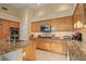 Open kitchen with stone countertops, stainless steel appliances, and light wood cabinetry at 24158 N 78Th Pl, Scottsdale, AZ 85255