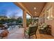 Relaxing covered patio seating area overlooks a freeform pool with a rock waterfall feature at 24158 N 78Th Pl, Scottsdale, AZ 85255