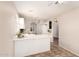 Open-concept kitchen with white cabinets, tile floors, and a convenient breakfast bar at 2503 E Camellia Dr, Gilbert, AZ 85296