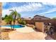 Resort-like pool with a rock waterfall feature, mature landscaping, and a built-in seating area at 2503 E Camellia Dr, Gilbert, AZ 85296
