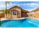 Backyard pool with rock water feature, well-maintained landscaping, and desert views at 2503 E Camellia Dr, Gilbert, AZ 85296