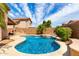 A beautiful freeform pool with a water feature, lush landscaping, and a spacious sun deck at 2503 E Camellia Dr, Gilbert, AZ 85296