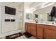 Well-lit bathroom featuring a double vanity, walk-in shower, and ample storage space at 2734 W Bowker St, Phoenix, AZ 85041