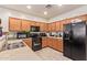 Functional kitchen with wooden cabinets, a black refrigerator, and a tile backsplash at 2734 W Bowker St, Phoenix, AZ 85041