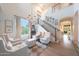 Open-concept living room with a staircase, hardwood floors, and large windows for natural light at 29966 N 72Nd Dr, Peoria, AZ 85383