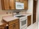Functional kitchen with white appliances, wooden cabinets, and tile floor at 314 E Campo Bello Dr, Phoenix, AZ 85022