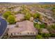 This aerial shows a sprawling desert community, pool, and lush landscaping for privacy and serenity at 31900 N 127Th Ln, Peoria, AZ 85383