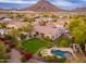 The backyard is an outdoor oasis with a pool, mature landscaping, manicured lawn, and covered patio at 31900 N 127Th Ln, Peoria, AZ 85383