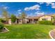 Spacious backyard with lush green lawn, mature trees, and a covered patio, perfect for entertaining and relaxation at 31900 N 127Th Ln, Peoria, AZ 85383