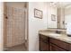 Tiled bathroom with a walk-in shower, dark wood vanity, granite countertops, sink, and decorative mirrors at 31900 N 127Th Ln, Peoria, AZ 85383