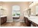 Dual sink bathroom with a view into the bedroom with a bed and exercise equipment at 31900 N 127Th Ln, Peoria, AZ 85383