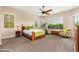 Bright bedroom with large windows, a ceiling fan, and an exercise bike at 31900 N 127Th Ln, Peoria, AZ 85383