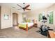 Spacious bedroom with a ceiling fan, large windows, and workout equipment at 31900 N 127Th Ln, Peoria, AZ 85383