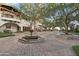Charming courtyard featuring a decorative fountain, tiled accents, and mature trees at 31900 N 127Th Ln, Peoria, AZ 85383