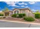 Charming exterior of a single-story home with a two-car garage, low-maintenance landscaping and a paved street at 31900 N 127Th Ln, Peoria, AZ 85383