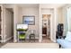 Inviting hallway leading to bathroom with a framed landscape photo and a stylish chair with entertainment center at 31900 N 127Th Ln, Peoria, AZ 85383