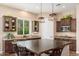Spacious kitchen features granite countertops, dark wood cabinetry, stainless appliances, and a large island at 31900 N 127Th Ln, Peoria, AZ 85383