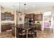 Well-equipped kitchen featuring dark wood cabinetry, stainless steel appliances, and a spacious island with seating at 31900 N 127Th Ln, Peoria, AZ 85383