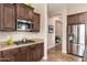 Modern kitchen with granite countertops, dark wood cabinets, and stainless steel appliances, perfect for culinary enthusiasts at 31900 N 127Th Ln, Peoria, AZ 85383