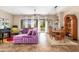 Spacious living room with tile floors, plush purple sofa, and large windows offering views of the landscaped backyard at 31900 N 127Th Ln, Peoria, AZ 85383