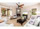 Bright living room with fireplace, ceiling fan, neutral color palette, and sliding doors to the patio at 31900 N 127Th Ln, Peoria, AZ 85383