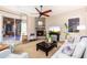 Bright living room with a stone fireplace, comfortable seating, and access to the covered patio at 31900 N 127Th Ln, Peoria, AZ 85383