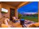 A cozy outdoor patio with comfortable seating and a tranquil view of the backyard at 31900 N 127Th Ln, Peoria, AZ 85383