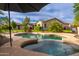 Inviting pool and spa surrounded by lush landscaping, complemented by a covered patio, perfect for outdoor living at 31900 N 127Th Ln, Peoria, AZ 85383