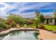 Sparkling pool surrounded by lush landscaping and comfortable lounge chairs, creating a serene and relaxing outdoor space at 31900 N 127Th Ln, Peoria, AZ 85383