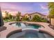 Inviting backyard pool with a hot tub surrounded by trees, flowering plants, and lounge chairs at 31900 N 127Th Ln, Peoria, AZ 85383