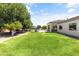 Expansive backyard with lush green grass, mature trees, and a view of the home at 3410 E Inglewood Cir, Mesa, AZ 85213