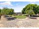 Spacious backyard with gravel, mature trees, and a distant view of the pool area at 3410 E Inglewood Cir, Mesa, AZ 85213